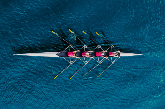 Barco com remadores representando colaboração.